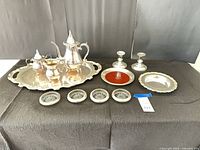 All 12 silver-plated pieces arranged on black cloth