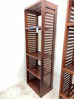 Front view of tall slatted wooden shelving unit