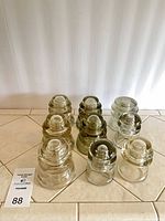 Group of nine glass insulators displaying overall quantity, color variations