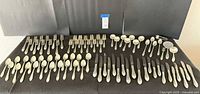 Full layout of Wallace sterling flatware set on black cloth