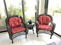 Two wicker chairs, side table, lantern in sunroom