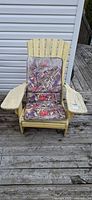 Front view of yellow wooden Adirondack chair with patterned cushion