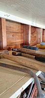 Shelf with assorted hand tools: pliers, hammer handles, wire brush, hacksaw frame visible