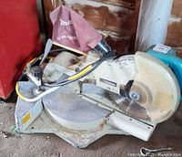 Full view of Makita LS1011 saw with dust bag, blade guard and cord