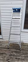 Front view of full aluminum step ladder showing four steps and blue tool tray top