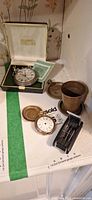 Group view showing Smiths pocket watch in box, Waltham watch, brass tot cup, screwdriver set