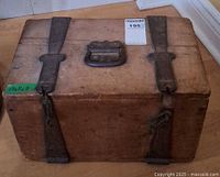 Top view of wooden trunk showing handle, metal straps, patina