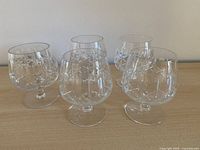 Five cut crystal brandy glasses in a row