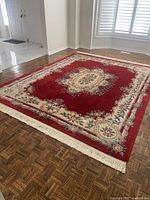 Full view of red floral area rug in room