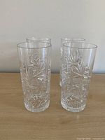 Four tall crystal highball glasses grouped on table