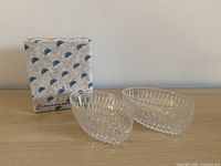 Two clear crystal holders beside original Princess House box