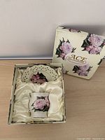 Open box showing cup and saucer nested in satin lining