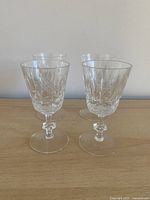 Four crystal sherry glasses standing upright