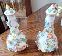 Front view of both porcelain scent bottles showing applied flowers and overall design