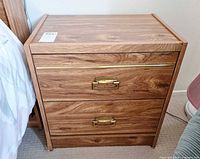 front view showing two drawers, brass pulls, woodgrain veneer