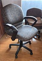 Front view of patterned fabric office chair with armrests and caster base