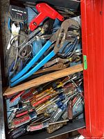 Drawer containing assorted screwdrivers, pliers and other hand tools