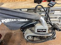 Full view of Porter-Cable belt sander with dust bag attached