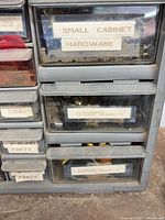 Front left section showing labeled drawers 'SMALL CABINET HARDWARE', 'SCREEN PARTS', hardware visible