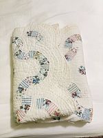 Folded quilt showing patchwork rings and quilting