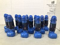 Group of 13 blue phallic water bottles standing upright
