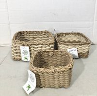 Three jute baskets with tags visible