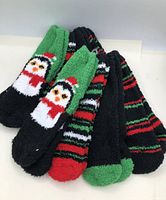 Eight pairs of fuzzy Christmas-themed socks arranged in stack