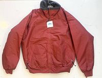 Front view of clay/red Tri-Mountain Mountaineer jacket with tags