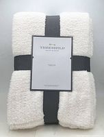 Front view of folded white throw with label