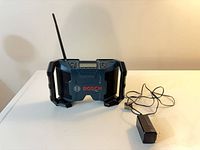 Front view of Bosch PB120 radio with antenna and power adapter
