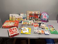 Overall view showing boxes, wooden puzzles, card sets and abacus on table