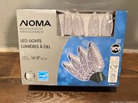 Front of sealed NOMA LED C9 string lights box showing product image and specifications