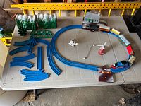 Full layout overview on table: locomotive, cars, track sections, tunnel, bridge, windmill, helicopter, station