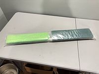 sealed package with green and teal microfiber pads visible