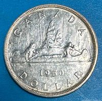 Reverse side of 1950 Canada silver dollar showing Voyageur design