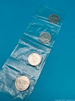 Four 1968 Canadian dollar coins in Royal Canadian Mint plastic strip