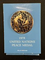 Obverse of medal on blue card showing 1978 United Nations Peace Medal text