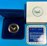 Coin in display case with outer box and certificate card visible