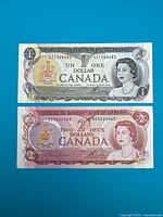 Fronts of $1 and $2 notes showing denominations, portraits, serial numbers