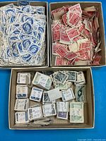 Three boxes containing blue, red and assorted Canadian stamps