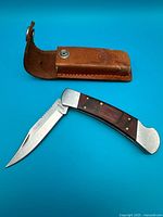 Knife open with sheath above, shows overall design and size