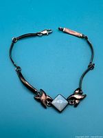 Full view of sterling silver bracelet laid flat, showing lobster clasp and overall design