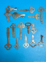 All fifteen vintage keys laid out on blue background showing variety