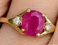 Close-up of ring on finger showing ruby and diamonds