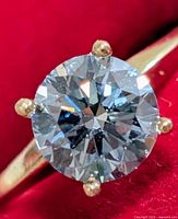 Close-up of round brilliant fancy light blue diamond in four-prong yellow gold setting