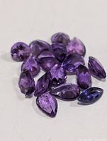Group of loose faceted amethyst stones showing shapes and color
