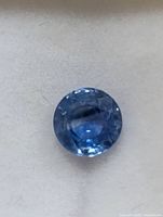 Close view of the round blue sapphire on white background