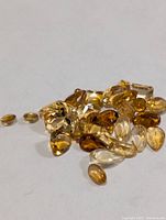 Loose citrine gemstones spread out showing variety of cuts and colors