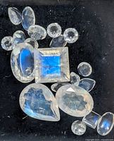Group of loose moonstones on black background showing various cuts