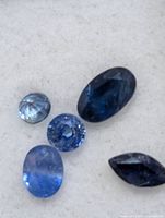 close-up of five loose blue sapphires